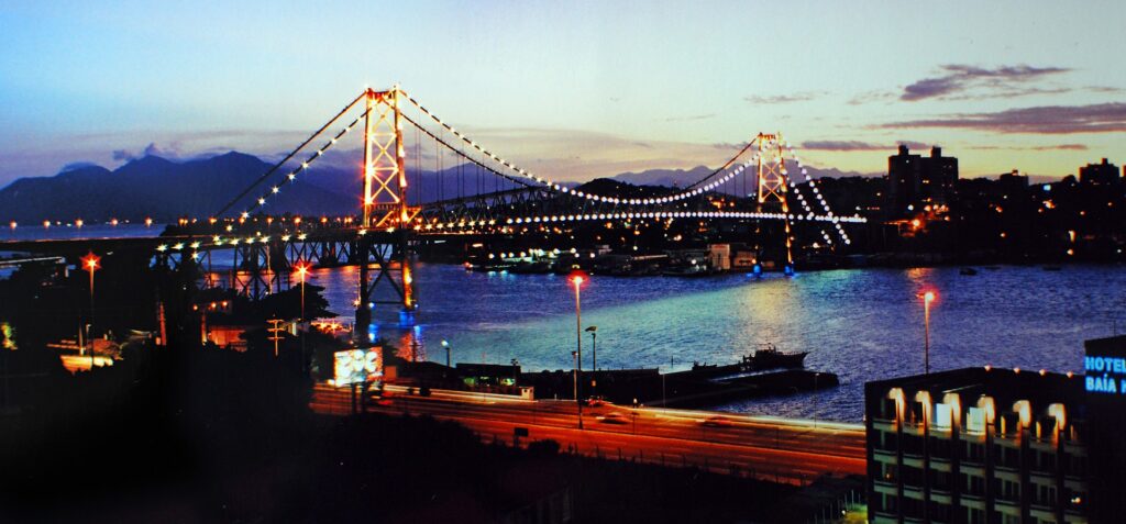 Ilustração do artigo Hotéis perto do aeroporto de Florianópolis - Veja as melhores opções | Ponte Hercilio Luz ao entardecer - Florianópolis-SC | Fonte. Wikimedia Commons - Ponte Hercilio Luz ao entardecer - Florianópolis-SC - por Carlos Alkmin.jpg